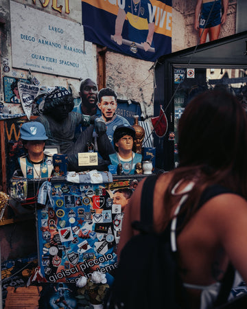 Woman looking at maradona memorabilia and other football memorabilia.