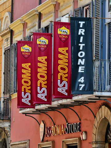 As roma banners hang outside a store.