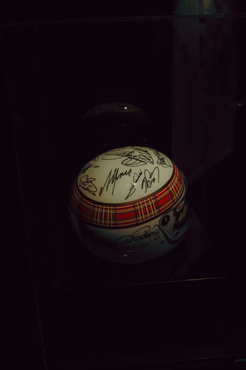 A signed racing helmet with tartan pattern