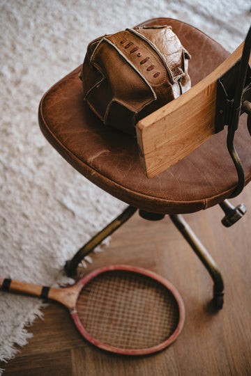 Vintage soccer ball and tennis racket on chair