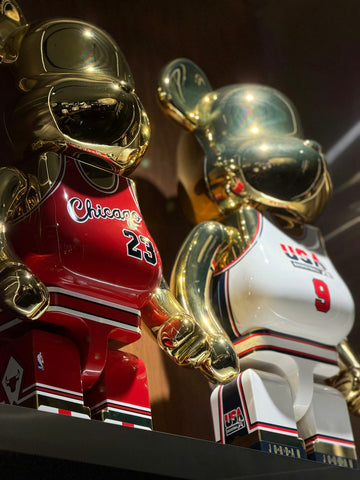 Two golden bear figures in basketball jerseys
