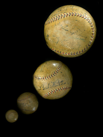 Three vintage baseballs on a black background