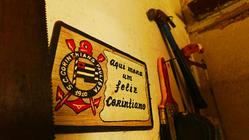 Corinthians logo sign with feliz corinthiano text on a wall.